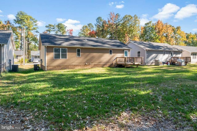 back of house with a deck, a lawn, and central AC