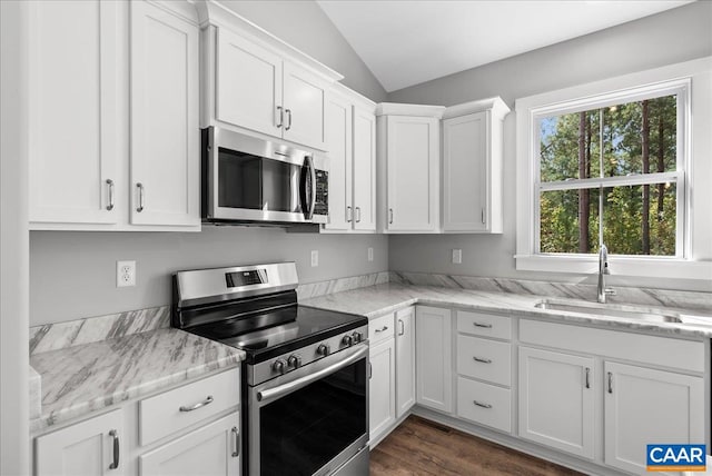 kitchen featuring lofted ceiling, white cabinets, dark wood-type flooring, sink, and stainless steel appliances