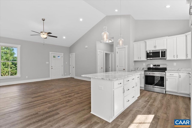 kitchen featuring dark hardwood / wood-style floors, stainless steel appliances, a kitchen island, and white cabinets