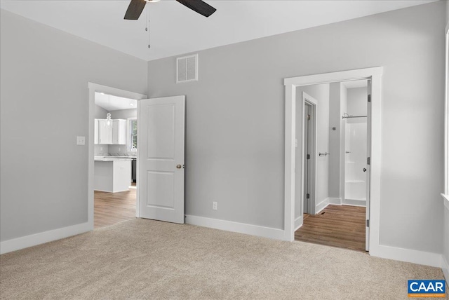 unfurnished bedroom with ceiling fan and light colored carpet