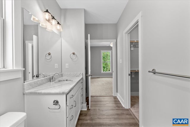 bathroom with vanity, wood-type flooring, toilet, and ceiling fan