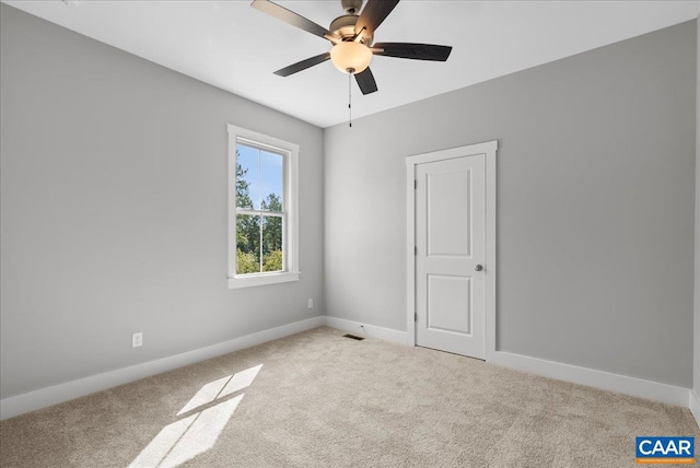 carpeted spare room with ceiling fan