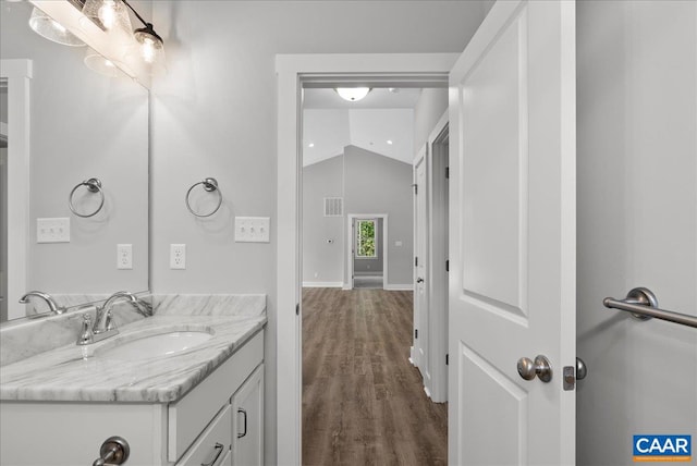 bathroom with vanity, vaulted ceiling, and hardwood / wood-style flooring