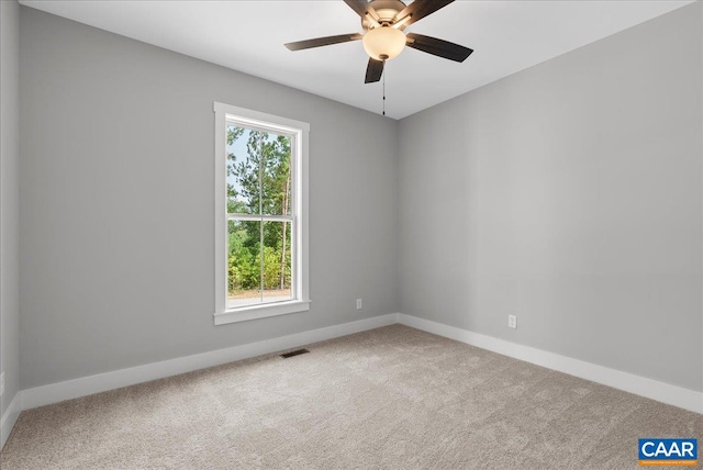 carpeted empty room featuring ceiling fan and plenty of natural light