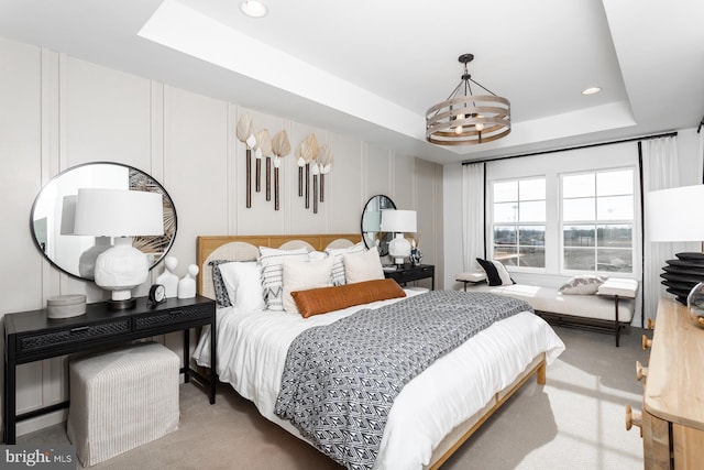 carpeted bedroom featuring a chandelier and a raised ceiling