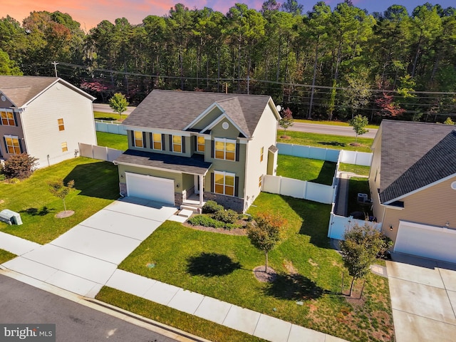 view of front of house featuring a garage and a lawn