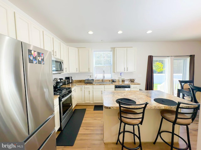 kitchen featuring appliances with stainless steel finishes, sink, plenty of natural light, and a kitchen island