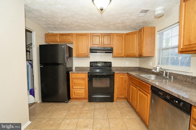 kitchen featuring black appliances, sink, light tile patterned floors, and a textured ceiling