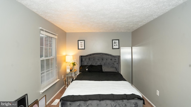 bedroom with a textured ceiling and carpet floors