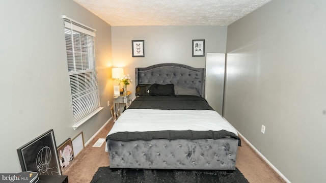 bedroom with a textured ceiling and carpet floors