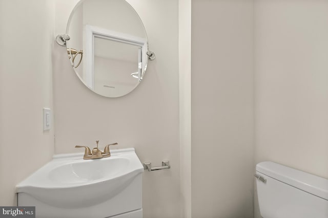 half bathroom with toilet and vanity