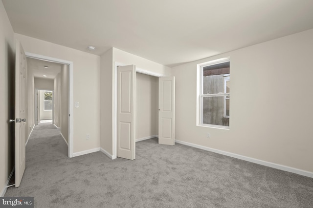 unfurnished bedroom featuring baseboards, a closet, and carpet flooring