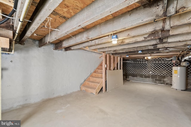 unfinished basement with water heater and stairway