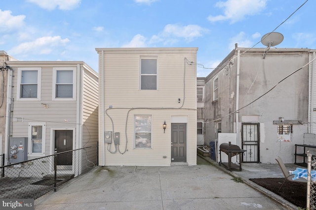 back of property featuring a patio and fence