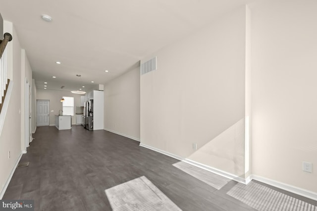 unfurnished living room with dark wood-type flooring and sink