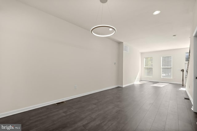 unfurnished living room featuring recessed lighting, dark wood-style flooring, baseboards, and visible vents