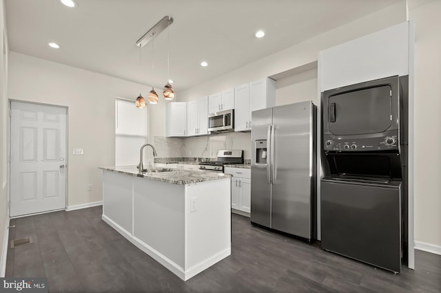 kitchen with pendant lighting, white cabinetry, stainless steel appliances, and an island with sink