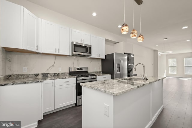 kitchen with white cabinets, a sink, appliances with stainless steel finishes, recessed lighting, and a kitchen island with sink