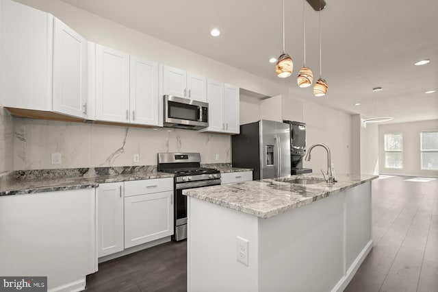 kitchen featuring sink, appliances with stainless steel finishes, decorative light fixtures, and white cabinets