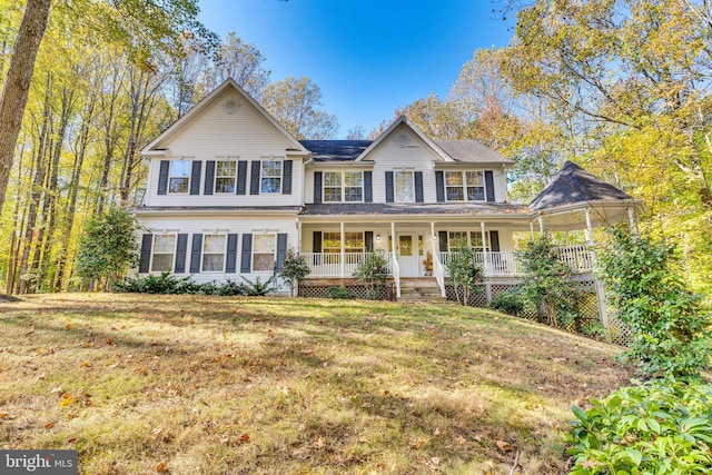 view of front facade featuring covered porch and a front yard