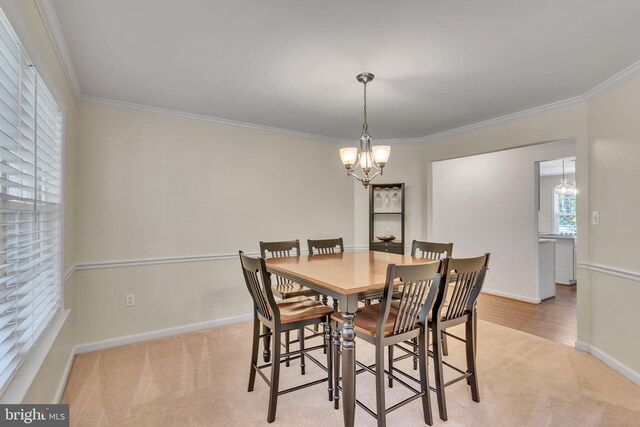 dining room featuring crown molding, light colored carpet, and a chandelier