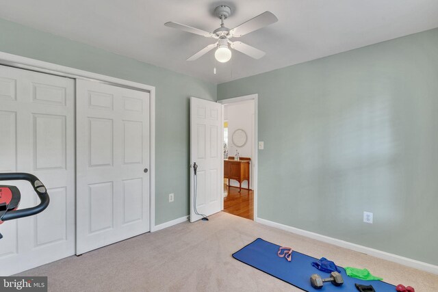 workout area featuring ceiling fan and light colored carpet