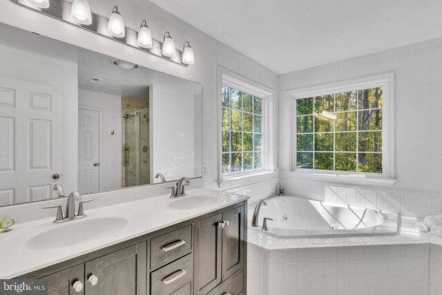 bathroom featuring vanity and shower with separate bathtub