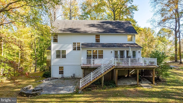 rear view of property with a yard, a deck, and a patio area