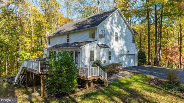 rear view of house with a deck and a garage