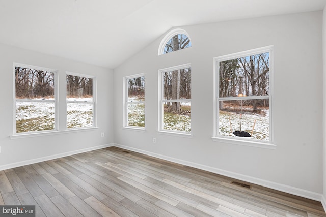 unfurnished sunroom featuring a healthy amount of sunlight and vaulted ceiling