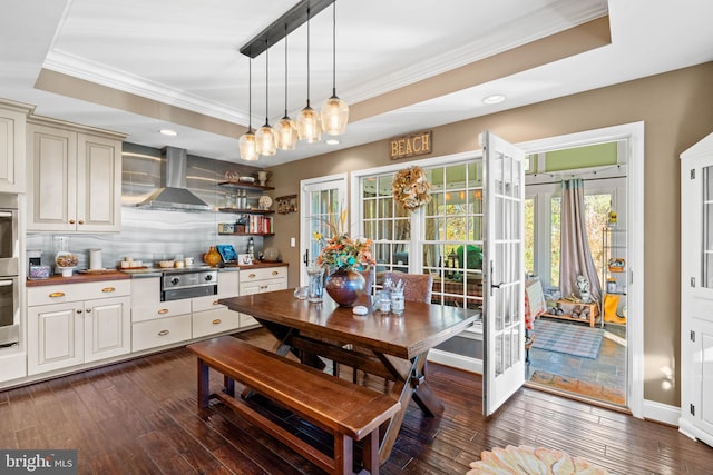 dining area with crown molding, french doors, dark wood-type flooring, and a tray ceiling