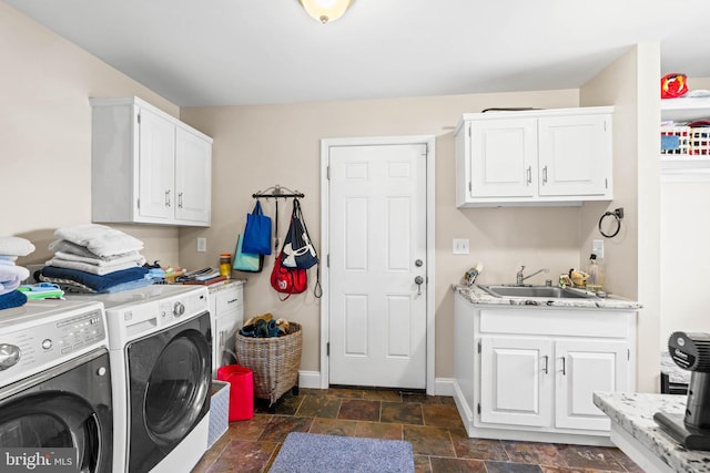 laundry room with cabinets, independent washer and dryer, and sink