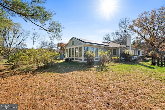 view of side of home featuring a lawn and a sunroom