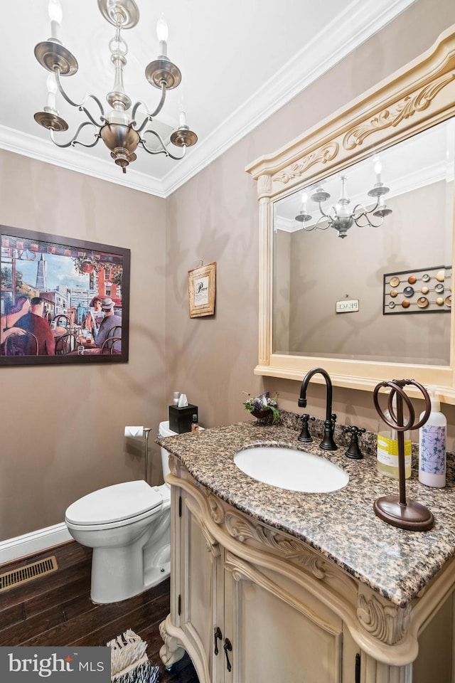 bathroom featuring wood-type flooring, vanity, toilet, and crown molding