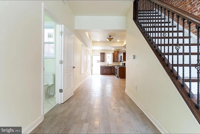 hallway with hardwood / wood-style flooring and sink