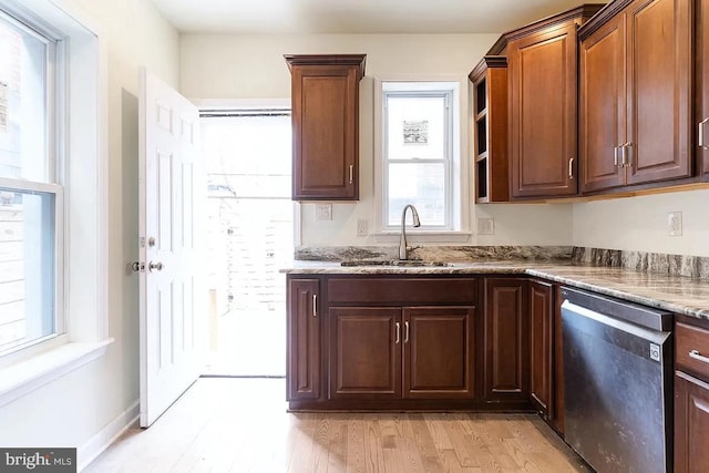 kitchen with sink, light hardwood / wood-style floors, light stone countertops, and dishwasher