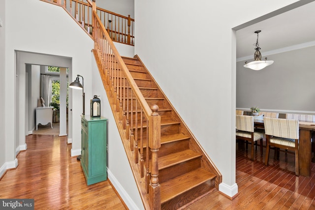 stairway featuring crown molding and wood-type flooring