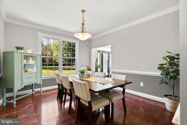 dining area featuring dark wood-type flooring and crown molding