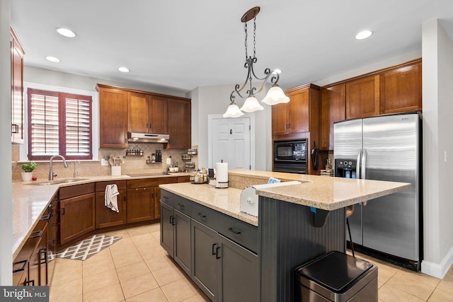 kitchen with a kitchen island, hanging light fixtures, backsplash, sink, and black appliances