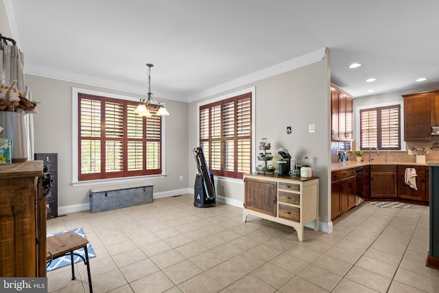 kitchen featuring a healthy amount of sunlight, ornamental molding, an inviting chandelier, and pendant lighting