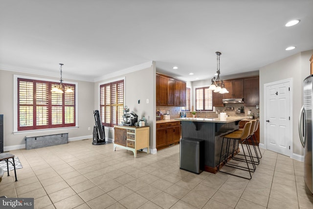 kitchen featuring a healthy amount of sunlight, tasteful backsplash, and decorative light fixtures