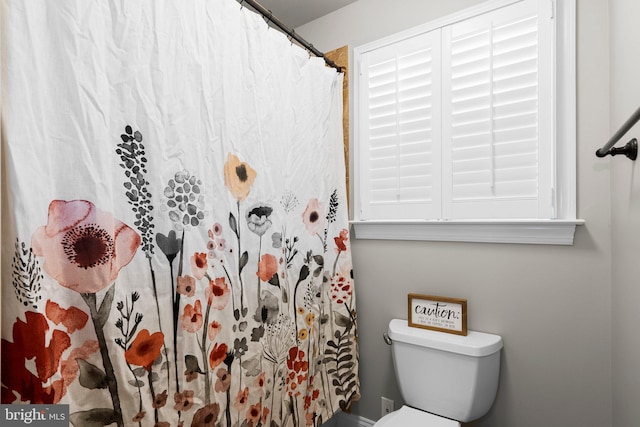 bathroom with curtained shower and toilet