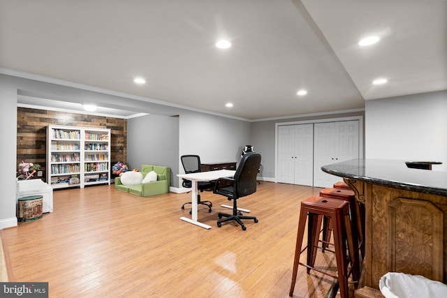 office featuring crown molding, light hardwood / wood-style flooring, and wooden walls