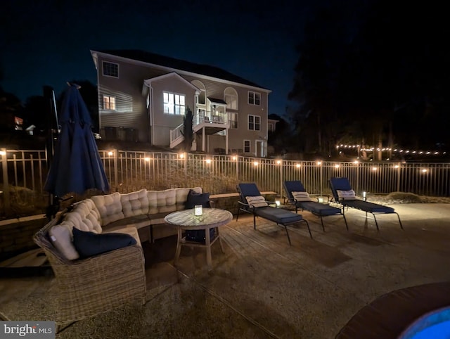 patio at twilight with a balcony and outdoor lounge area