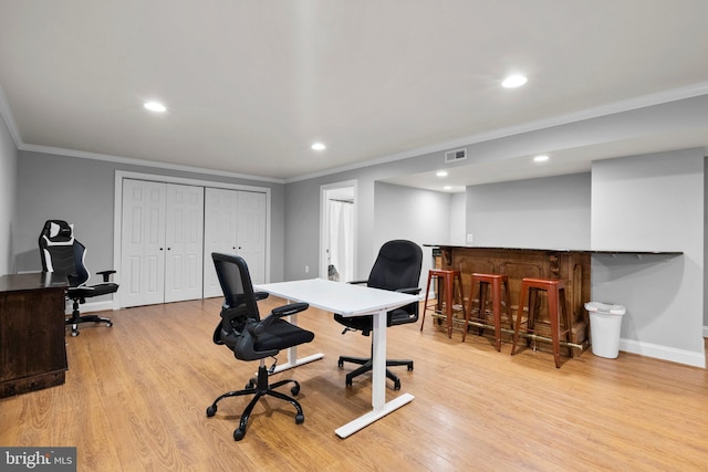 office with ornamental molding, bar, and light wood-type flooring