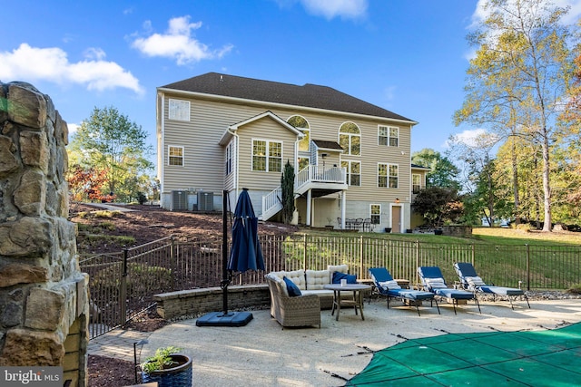 back of property featuring central AC, outdoor lounge area, a covered pool, and a patio