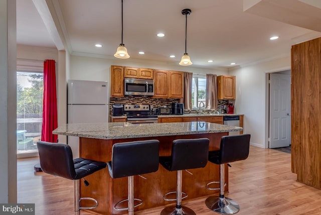 kitchen with appliances with stainless steel finishes, a center island, and a wealth of natural light