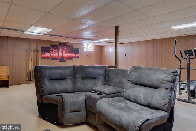 home theater room featuring a paneled ceiling and wood walls