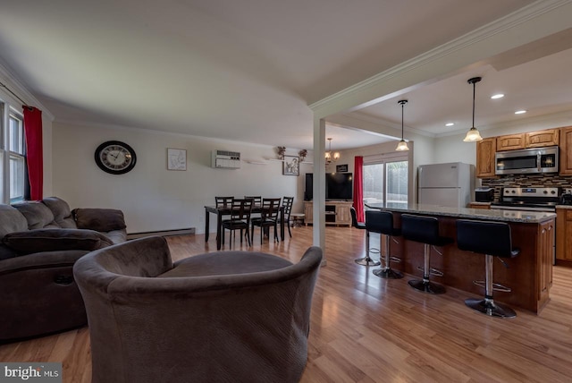 living room with a wall mounted AC, ornamental molding, a baseboard heating unit, and light hardwood / wood-style floors