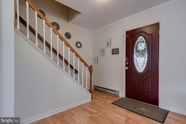 foyer entrance featuring a baseboard radiator, crown molding, and light wood-type flooring